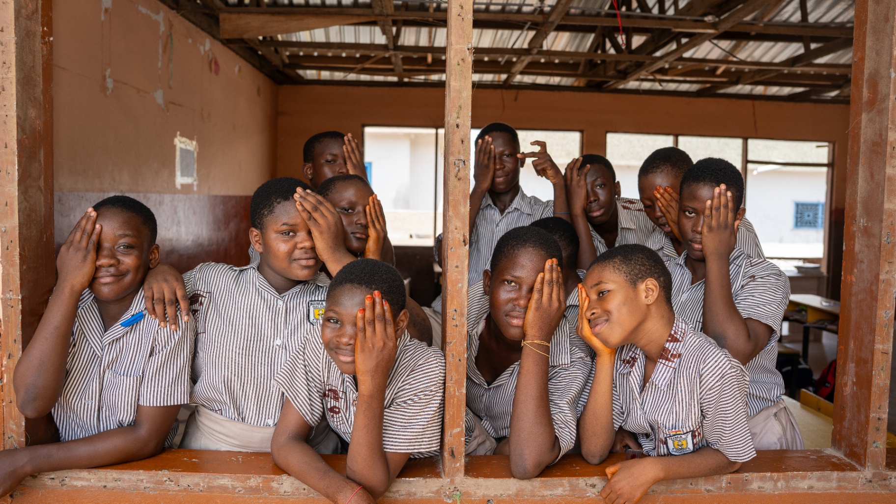 Schoolchildren gathered at a classroom window during outreach